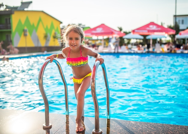 Heureuse petite fille jolie en maillot de bain coloré