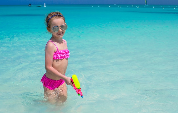 Heureuse petite fille jouant sur la plage pendant les vacances des Caraïbes