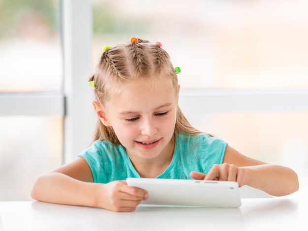 Heureuse petite fille jouant avec téléphone