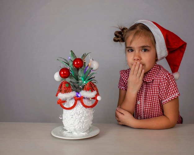 Heureuse petite fille mignonne près du visage du père noël fait avec de l'ananas