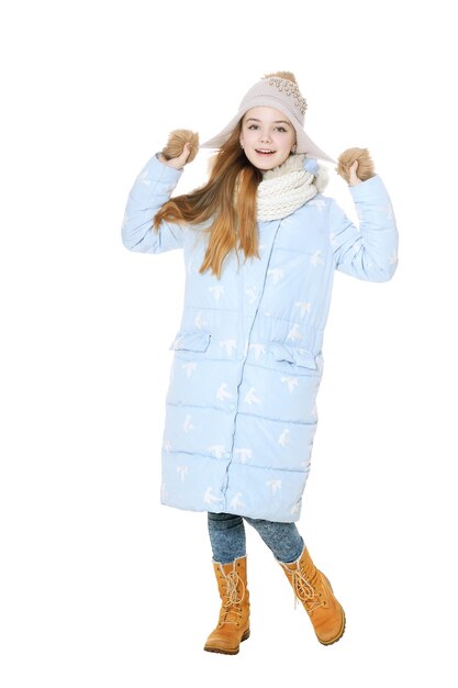 Heureuse petite fille posant en manteau isolé