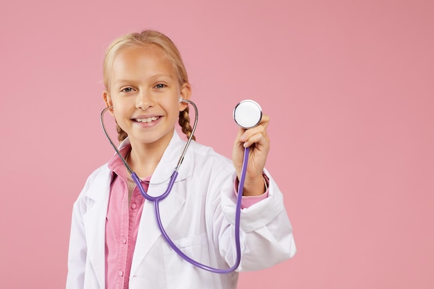 Photo heureuse petite fille rêvant de devenir médecin