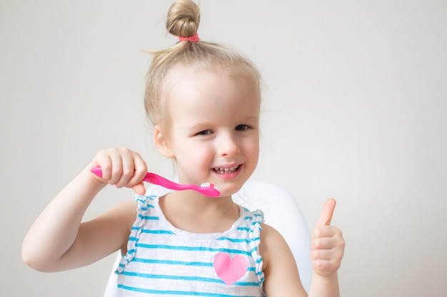 Heureuse petite fille se brosser les dents, brosse à dents rose, hygiène dentaire, mode de vie sain matin nuit