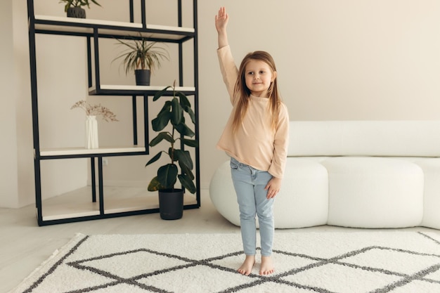 Heureuse petite fille souriante à la maison fille regarde la caméra