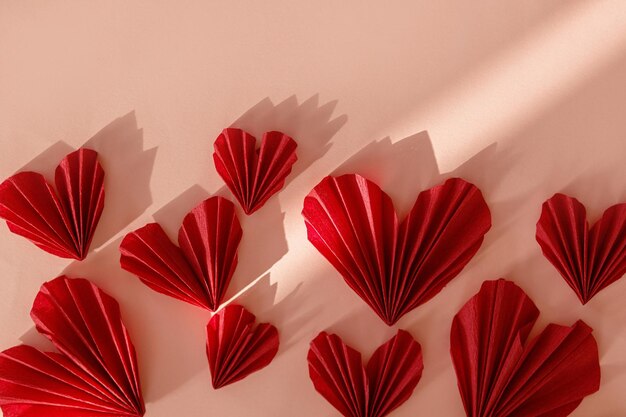 Heureuse Saint-Valentin Coeurs rouges élégants à plat sur fond de papier rose Découpes de coeur de la Saint-Valentin mignon moderne espace pour le texte Bannière d'amour créatif