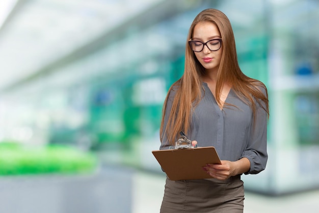 Heureuse souriante belle jeune femme avec presse-papiers