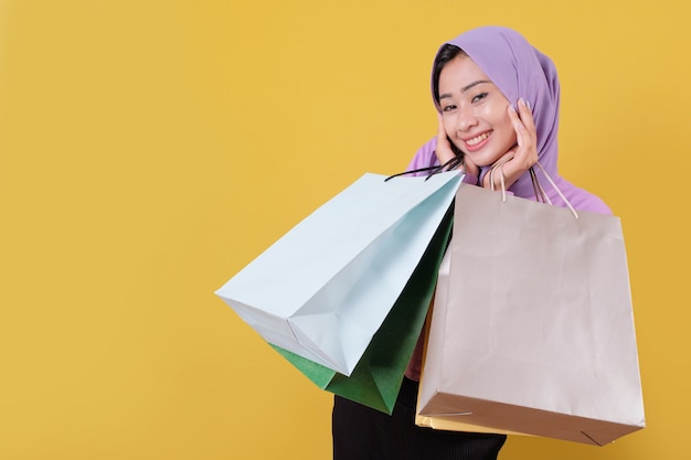 Heureuses belles femmes asiatiques accro du shopping tenant des sacs à provisions, joyeux et joyeux