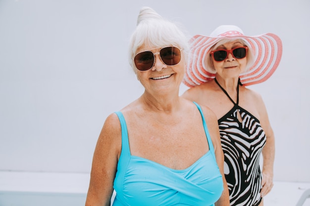 Heureuses femmes âgées faisant la fête dans la piscine - Amis âgés se relaxant lors d'une fête au bord de la piscine