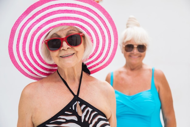 Heureuses femmes âgées faisant la fête dans la piscine - Amis âgés se relaxant lors d'une fête au bord de la piscine