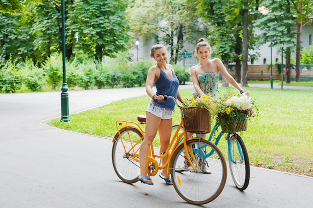 Heureuses femmes à vélo dans le parc