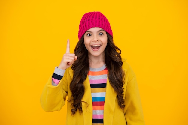 Heureux adolescent émotions positives et souriantes d'une adolescente Portrait d'une adolescente mignonne pointant vers le haut avec le doigt La fille a une excellente nouvelle idée