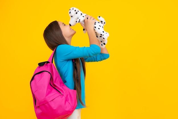 Heureux adolescent portrait école adolescent enfant fille avec sac à dos tenir jouet étude amusante éducation et concept de l'enfance fille souriante