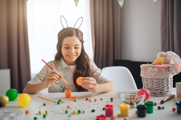 Heureux adolescent positif peignant des oeufs