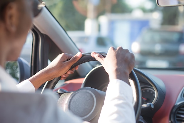 Heureux afro-américain conduisant une voiture, en été