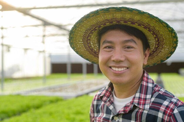 Heureux agriculteur travaillant dans une serre hydroponique, une alimentation propre et un concept d'alimentation saine