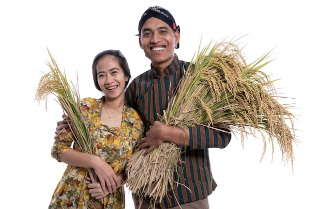 Heureux agriculteurs asiatiques détenant des grains de riz