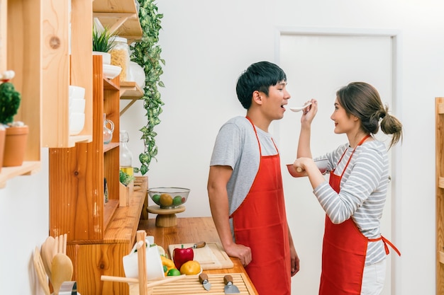 Heureux amant asiatique ou couple cuisinant dans l&#39;action de bonheur dans la salle de cuisine