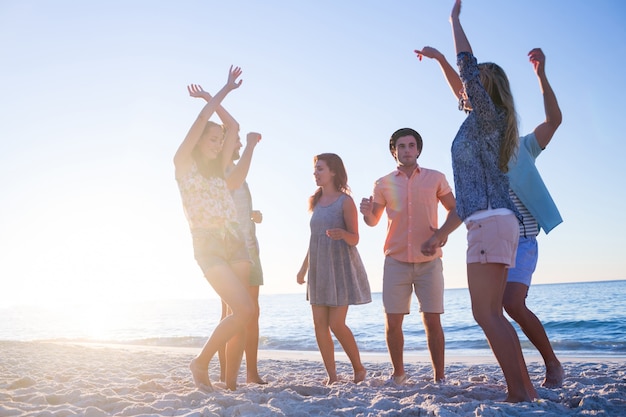 Heureux amis dansant sur le sable