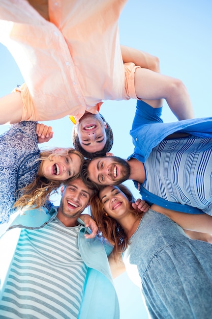 Heureux amis debout en cercle et en regardant la caméra