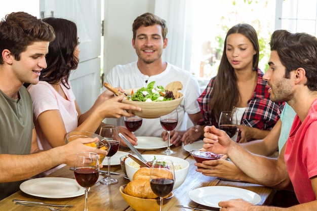 Heureux amis déjeunant à table