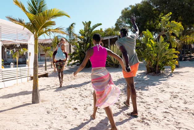 Heureux amis divers marchant sur la plage. Passer du temps de qualité, style de vie, amitié, été et concept de vacances.