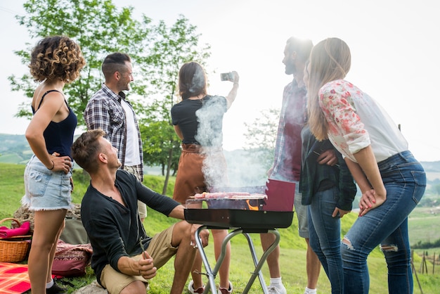 Heureux amis faisant du barbecue à l'extérieur