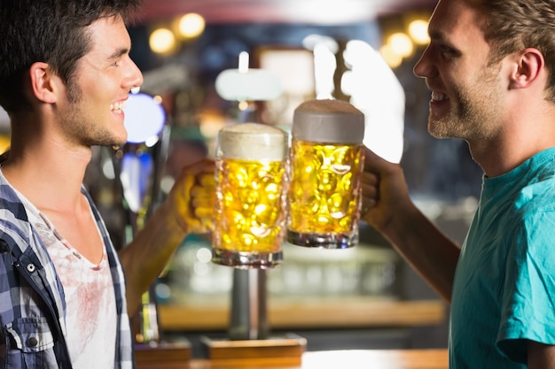 Heureux amis grillage avec des cruches de bière