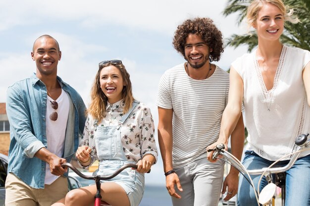 Heureux amis multiethniques bénéficiant d'une belle journée ensoleillée avec des vélos