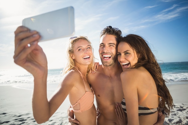 Heureux amis prenant selfie sur la plage