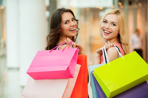 Heureux amis shopping. Deux belles jeunes femmes faisant du shopping au centre commercial