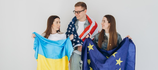 Heureux amis tenant le drapeau Ukraine USA et UE