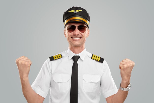 Heureux aviateur masculin faisant un geste oui et souriant