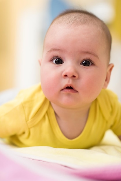 heureux beau bébé garçon nouveau-né allongé sur des couvertures colorées tout en jouant aux premiers jeux sur le sol à la maison