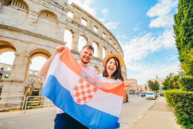 Heureux beau couple devant le Colisée à Pula Croatie avec drapeau croate