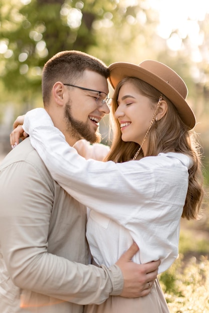 Heureux beau couple étreignant dans la forêt en souriant fille et garçon s'aiment ensemble l'heure d'été