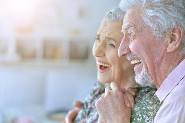 Heureux beau couple de personnes âgées posant à la maison