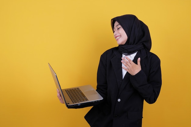 Heureux beau jeune travailleur féminin sur fond jaune