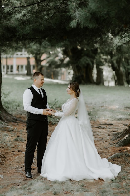 Heureux beau marié et brune belle mariée en robe blanche