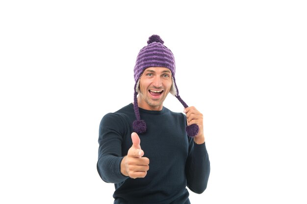 Heureux beau mec en hiver chapeau tricoté chaud doigt pointé isolé sur blanc, mode.