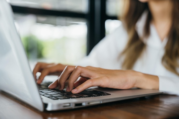 Heureux beau pigiste tapant du clavier sur un ordinateur portable travaillant en ligne à l'extérieur du bureau