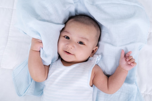 Heureux bébé couché sur un lit