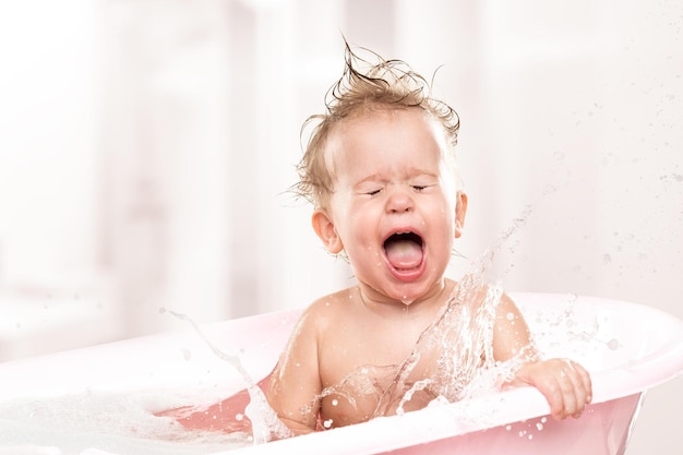 Heureux bébé drôle rire et baigné dans le bain