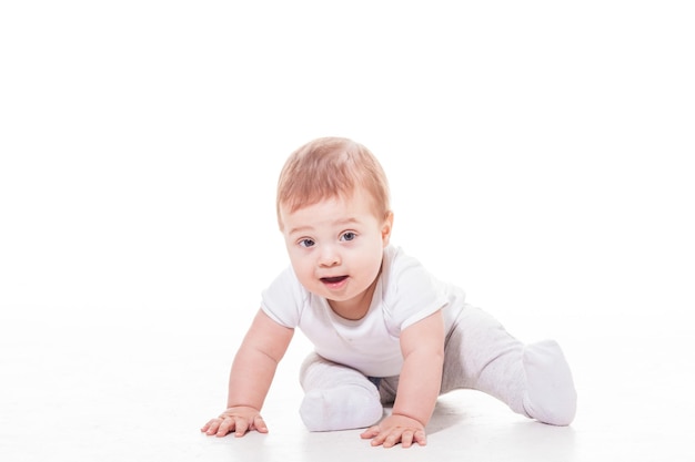 Heureux bébé joue sur le sol sur fond blanc