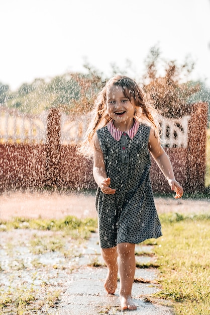 Heureux bébé souriant. petite fille qui court au coucher du soleil en plein air.