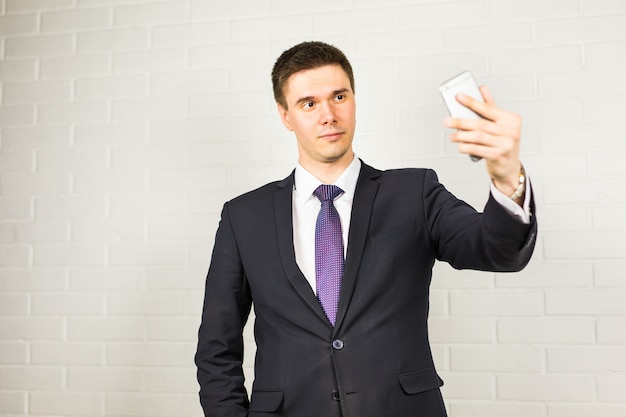 Heureux bel homme d'affaires prenant selfie au bureau