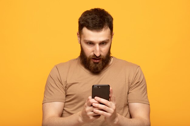 Heureux bel homme à l'aide d'un smartphone