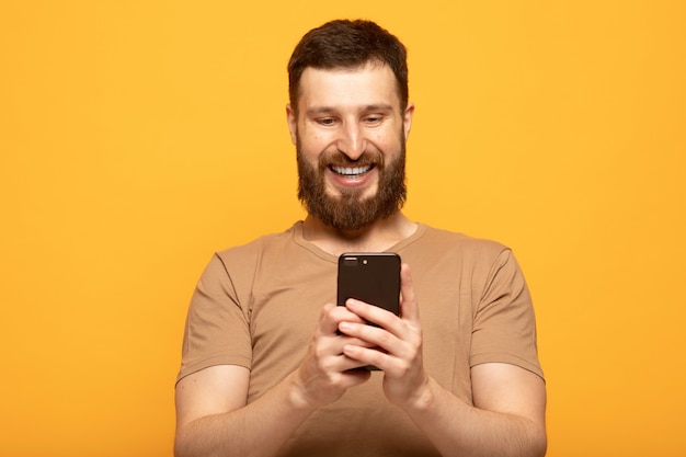 Heureux bel homme à l'aide d'un smartphone