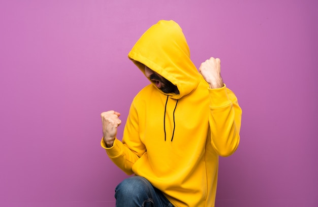 Heureux bel homme avec un sweat-shirt jaune