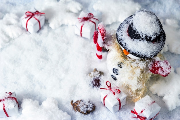 Heureux bonhomme de neige et boîte-cadeau sur la neige