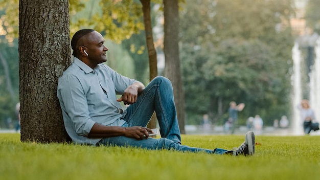 Heureux calme détendu homme âgé d'âge moyen à l'écoute de la musique avec des écouteurs adulte senior mature